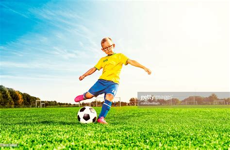 Boy Plays Soccer On Field And Kicks Football High Res Stock Photo