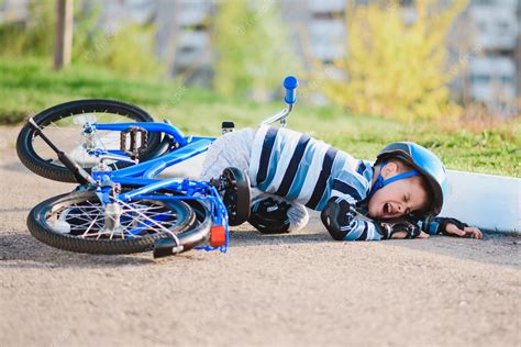Premium Photo A Small Child Fell From A Bicycle Onto The Road Crying