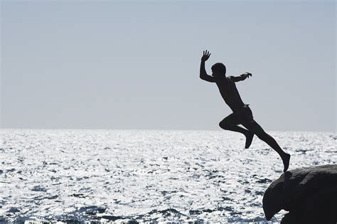 Teenage Boy Jumping Into Ocean License Image 70507125 Lookphotos