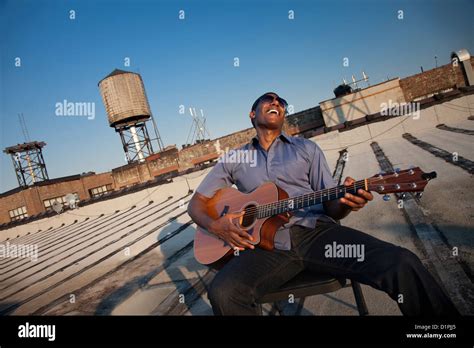 Black Man Playing Guitar On Rooftop Stock Photo Alamy