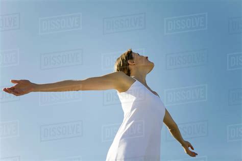Woman With Outstretched Arms Looking Up Low Angle View Stock Photo