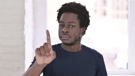 Portrait Of Young African American Man Saying No With Finger Sign Stock