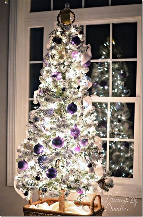 A White Christmas Tree With Purple And Silver Ornaments In A Basket