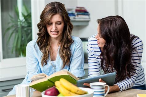 Female Friends Discussing Holding Book Digital Tablet Stock Photos