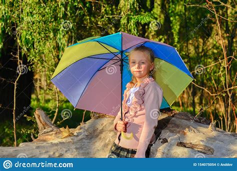Beautiful And Cute Girl With A Color Umbrella In The Fall In The Park