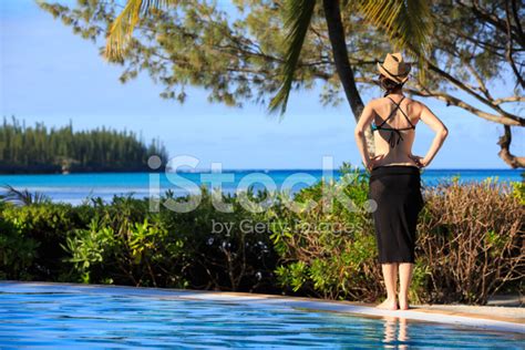 Woman Relaxing In A Tropical Infinity Swimming Pool Stock Photo