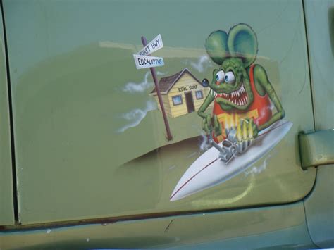 A Sticker On The Side Of A Vehicle Depicting A Rat Surfing In Front Of