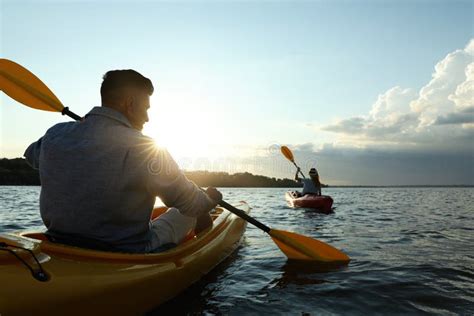 Couple Kayaking On River At Sunset Back View Summer Activity Stock