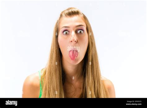 Close Up Of Young Woman Teasing With Sticking Her Tongue Out Over White