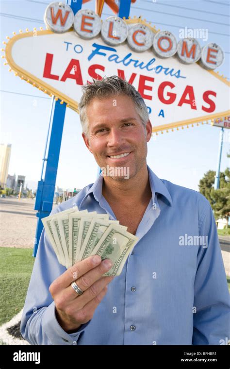 Mid Adult Man Holding Notes In Front Of Welcome To Las Vegas Sign