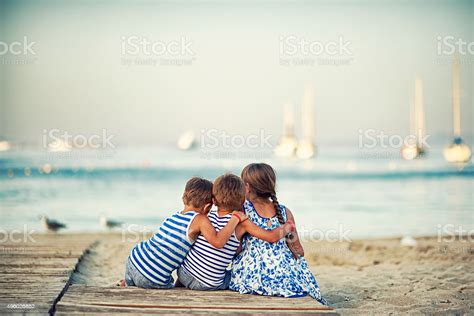 Kinder Sitzen Am Strand Am Abend Und Umarmen Stockfoto Und Mehr Bilder