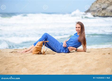 mooi jong meisje die op het strand op vakantie haar dichtbij ontspannen zak stock foto image