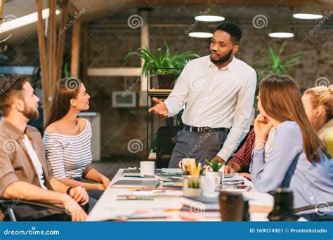 Young Boss Talking To Employees Having Board Meeting Stock Image