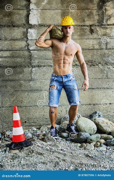 hot muscular construction worker shirtless carrying barrel royalty free stock image