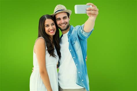 casal hipster feliz tirando uma selfie contra a vinheta verde foto premium