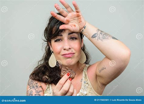 Tattooed Woman Looking At The Camera With Her Hand On Her Head And