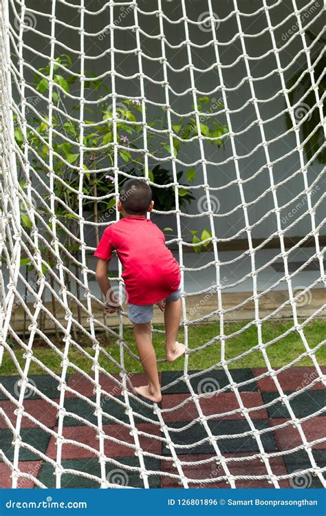 Boy Climbing A Rope Net On The Playground Stock Photo Image Of
