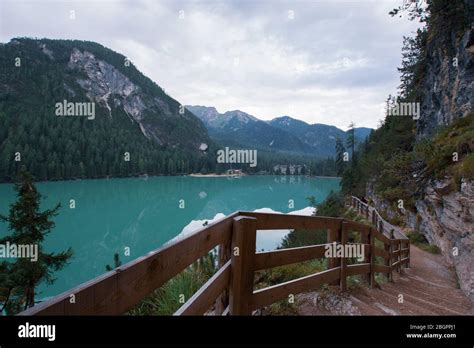 Dirt Path To Staircase Runs Along The Braies Lake Under A Cloudy Sky