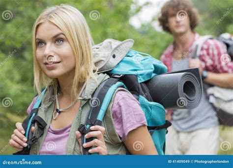 beautiful female backpacker looking away with man in background at forest stock image image of