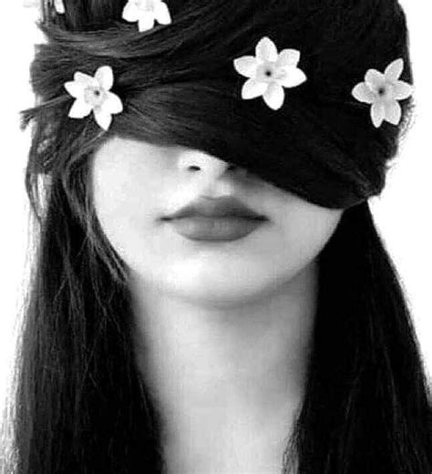 A Woman With Long Black Hair And Flowers In Her Hair Is Wearing A Blindfold