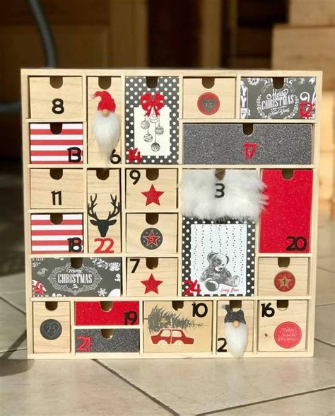 A Wooden Christmas Calendar With Santa Claus S Hat And Reindeers On The