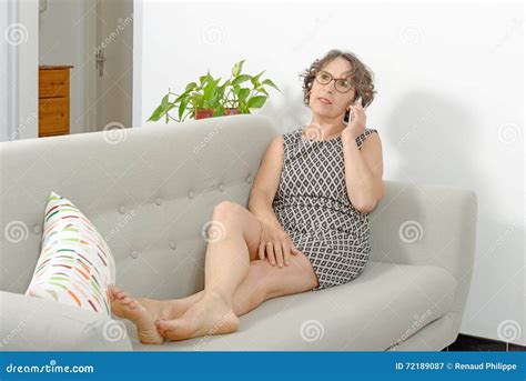 rijpe vrouw op de bank met een telefoon stock afbeelding image of comfortabel telefoon 72189087