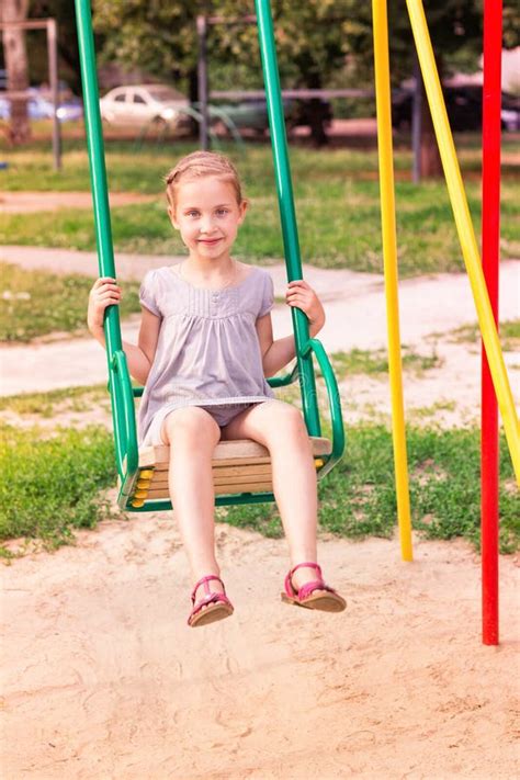 Beautiful Little Girl On A Swings Outdoor In The Playground Stock