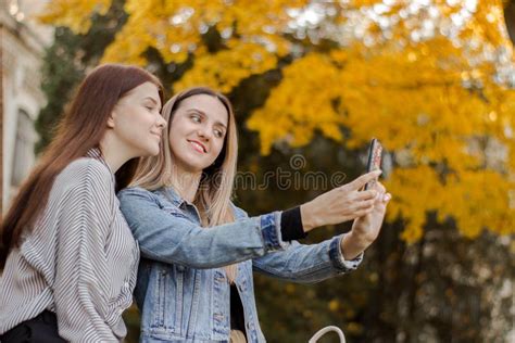 Two Beautiful Young Girls Taking Selfie On The Phone In The Autumn Park Stock Image Image Of