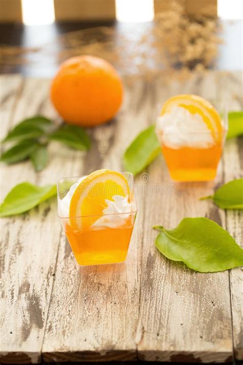 Orange Jelly In A Cup With Whipped Cream And Orange Sliced On Bl Stock
