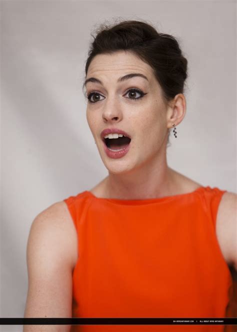 A Woman In An Orange Dress Making A Surprised Face