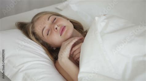 Beautiful Girl Sleeping In Bed Smiling In Her Sleep And Turning On Her Side Panning Camera