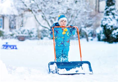 Cute Little Kid Boy In Colorful Winter Clothes Having Fun With Snow