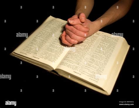 A Mans Hands Clasped In Prayer Over A Bible Stock Photo Alamy