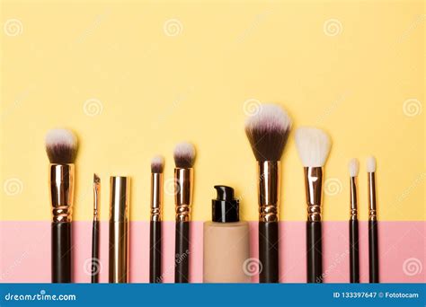 Make Up Brushes With Cosmetic Supplies On Coloured Background Stock
