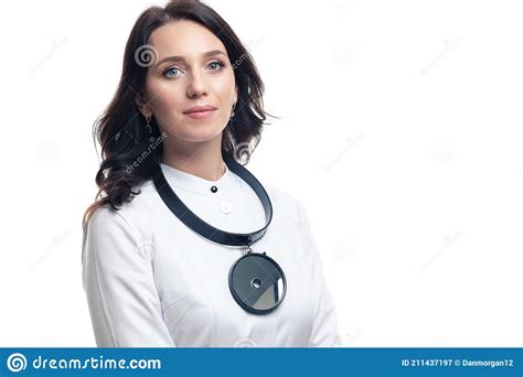 Tranquil Portrait Of Professional Smiling Female Gp Doctor Posing In Doctor`s Smock And An