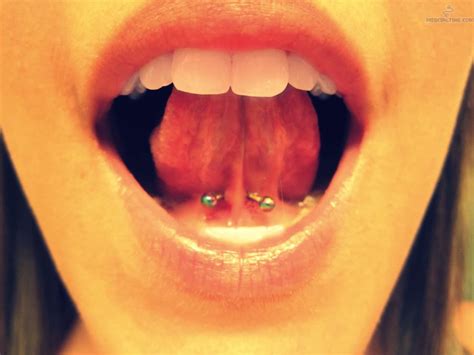 tongue frenulum piercing with gold barbell