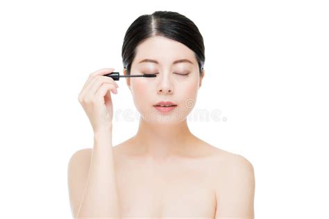 Young Beautiful Asian Woman Applying Mascara On Eyelashes Stock Image