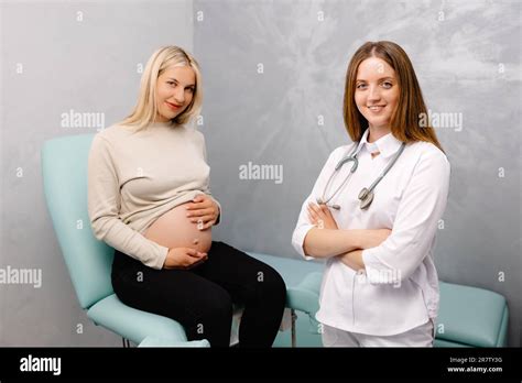 Gynecologist Preparing For An Examination Procedure For A Pregnant Woman Sitting On A
