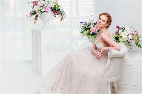 portrait of a beautiful girl in a wedding dress bride in luxurious dress sitting on a chair