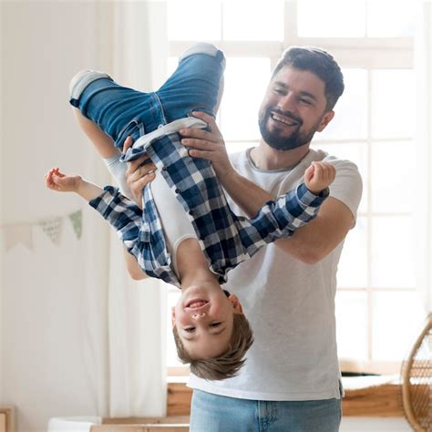 Premium Photo Father Holding His Son Upside Down