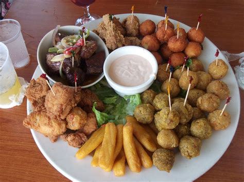 A Plate Full Of Appetizers And Dips With Dipping Sauce On The Side