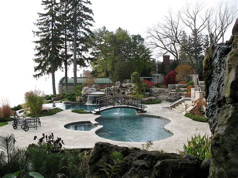 A pretty green wrought iron and wood arched bridge over a small manmade pool. 25 Fascinating Pool Bridge Ideas That Leave You Enthralled!