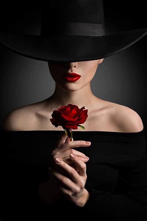 Фото Девушка в шляпе с красной розой в руках