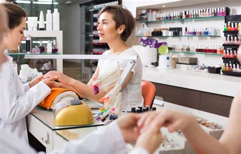 Manicurists Giving Manicure To Female Clients At Nail Salon Stock Image Image Of Hand