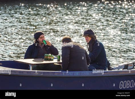 Three Men On A Boat In A Canal In Copenhagen Denmark Relaxing Having Tuborg Classic Beer