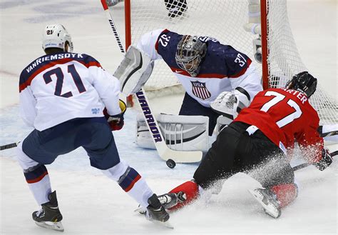 team usa s goalie quick makes a save between team usa s van riemsdyk and canada s carter during