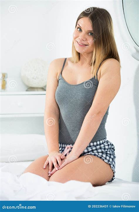 Smiling Girl Is Posing Playfully And Sitting On Bed Stock Image Image