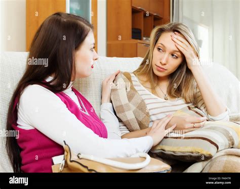 Young Woman Comforting Sad Friend At Sofa In Home Stock Photo Alamy