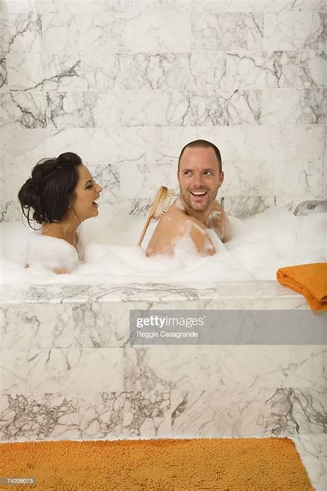Couple Sitting In Bubble Bath Woman Washing Mans Back Side View High