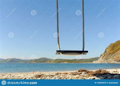 Rope Swing On The Shore Of The Gorgeous Azure Sea Sandy Beach And